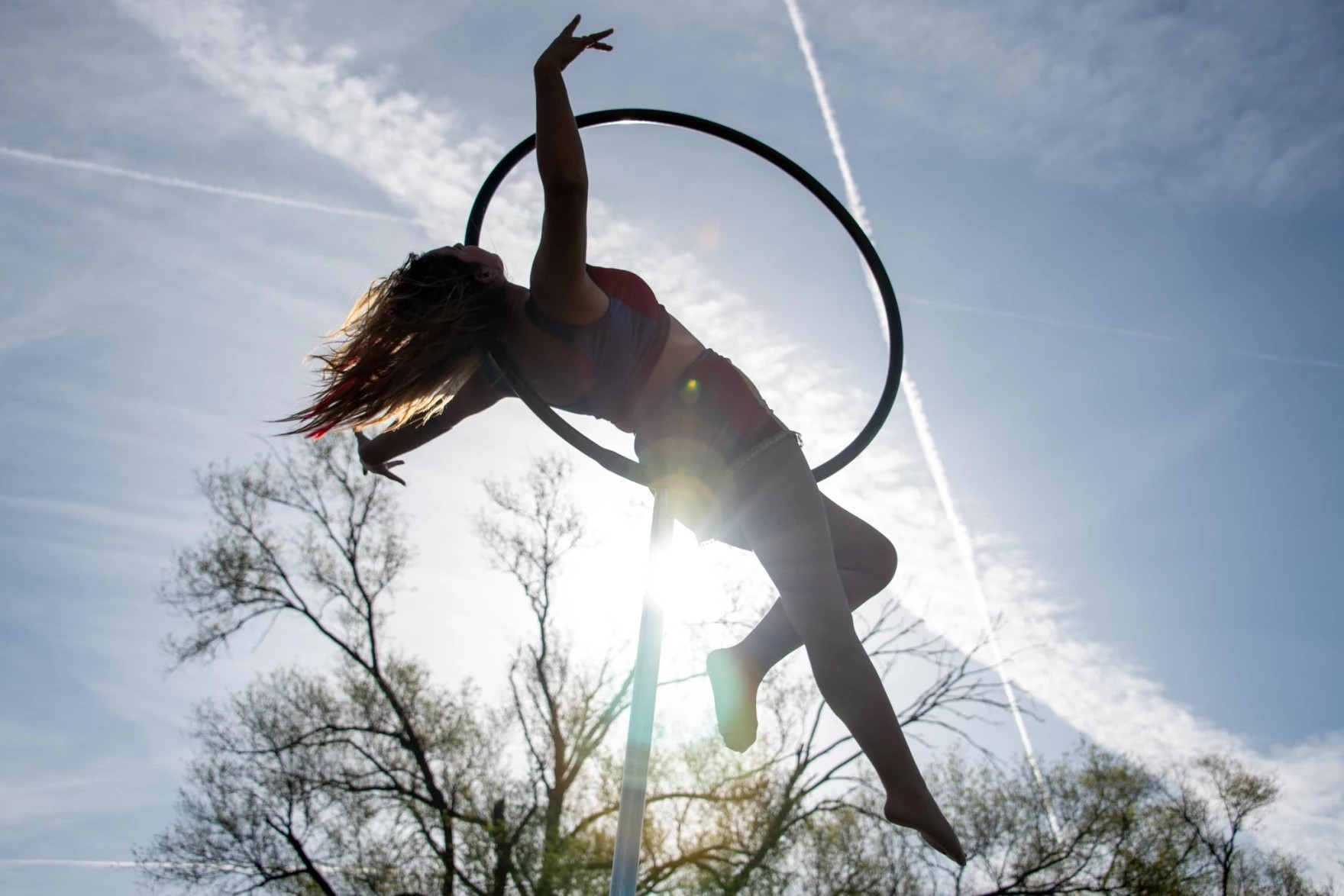 Maylissa Quinn warms up on a device she calls a "lollipop" — a metal ring on a pole that spins as she twirls in mid-air.