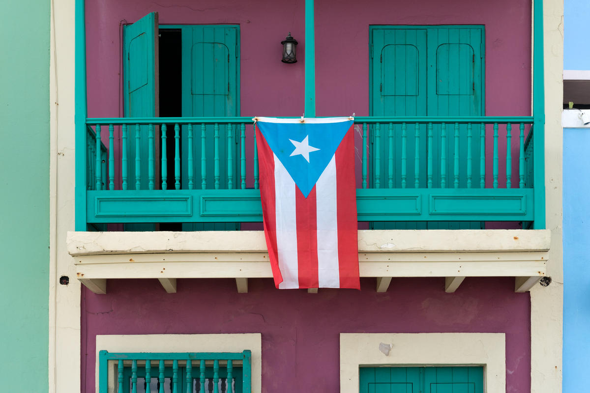 The flag of Puerto Rico hanging from a balcony. 