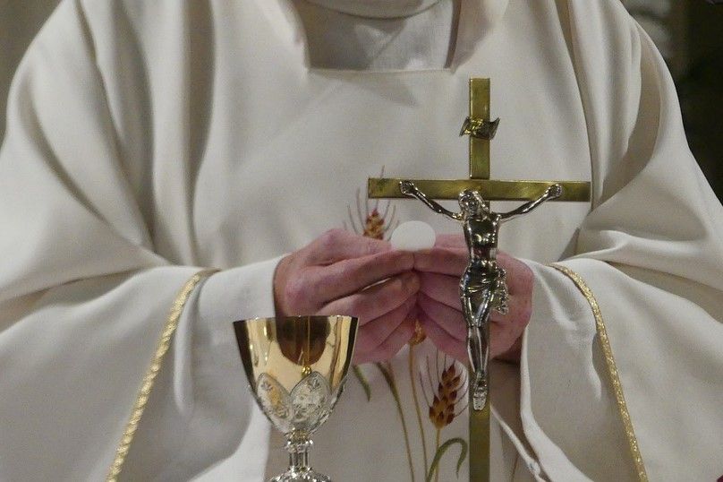 A Catholic priest conducts Communion.