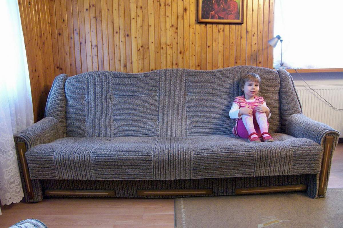 girl sitting on the far right of a gray couch