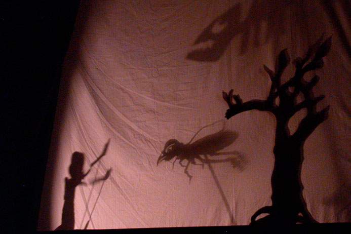 Scene from a shadow puppet play featuring scary flying creatures.