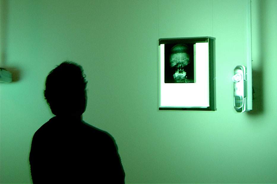 Silhouette of man looks at illuminated brain scan.