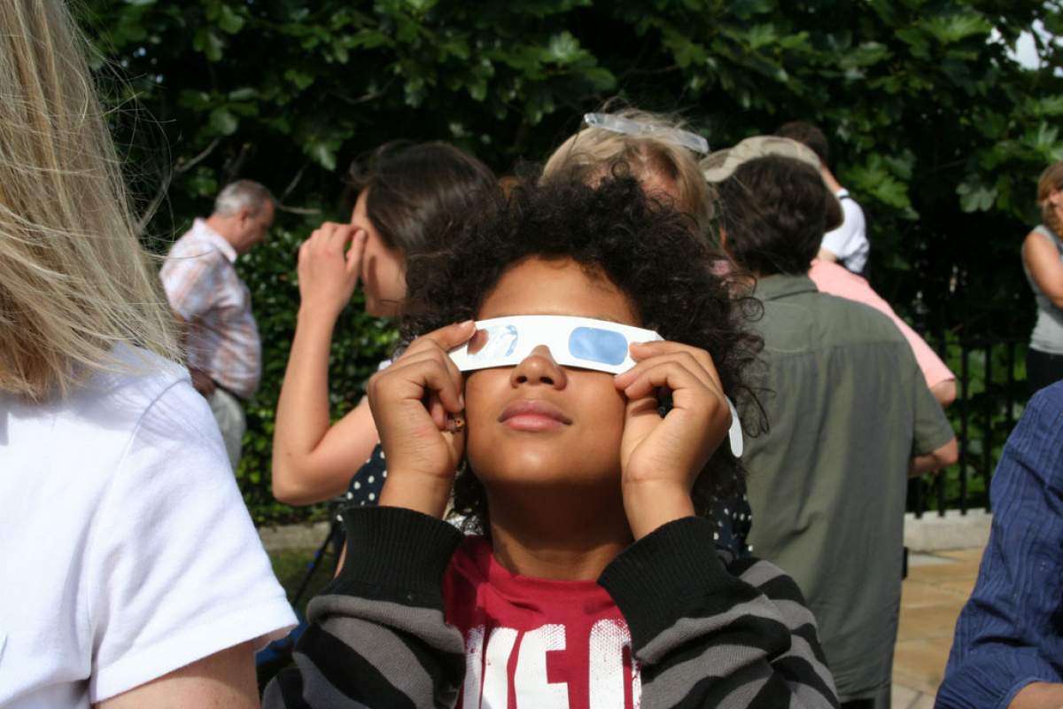 A child wearing eclipse glasses