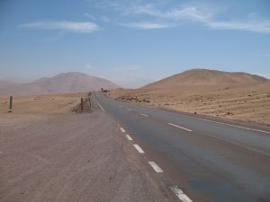 The highway road through the Atacama desert, heading off towards tall hills