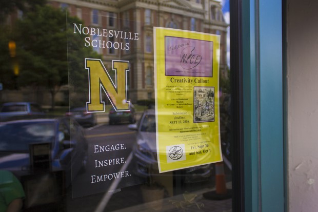 A poster for Noblesville Schools hangs in a coffee shop window of Noble Coffee and Tea Company. (Peter Balonon-Rosen/Indiana Public Broadcasting)