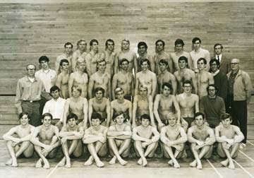 The team poses for a portrait in a gymnasium.