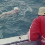 Coach Tom Hetzel looks on from the boat as Doc swims the channel.