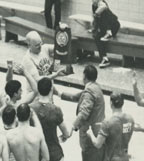 A cheering crowd surrounds Doc as he holds an NCAA trophy.