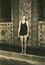 Jim, in a one-piece suit, stands at the edge of an indoor pool.