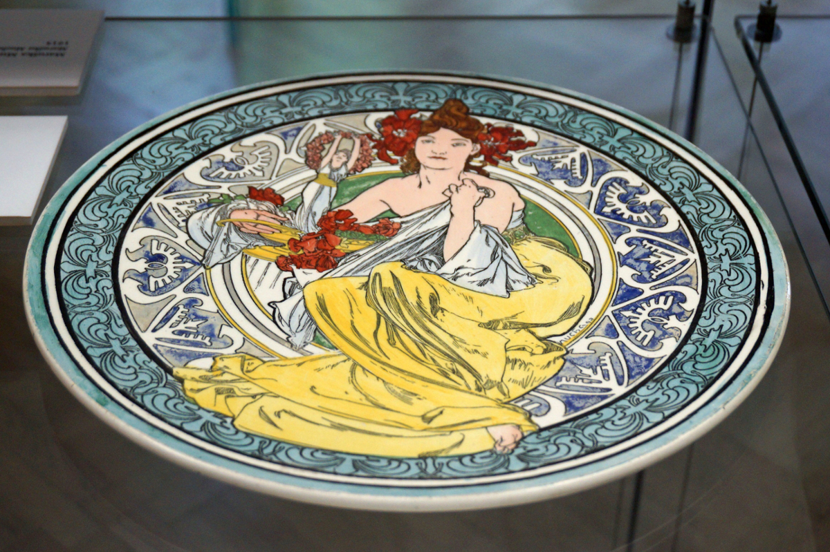 A colorful porcelain plate with a design of a Grecian woman