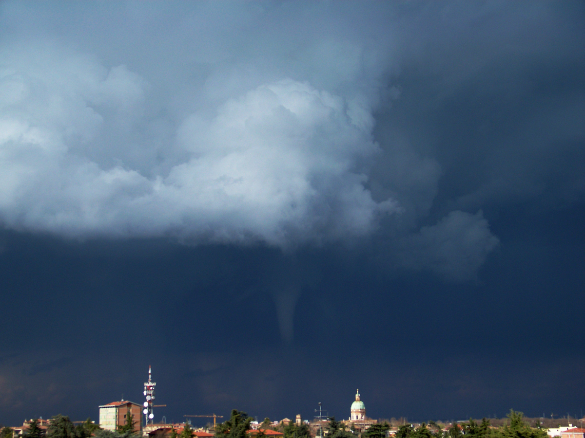 A tornado begins to form in a sky with large, dark clouds