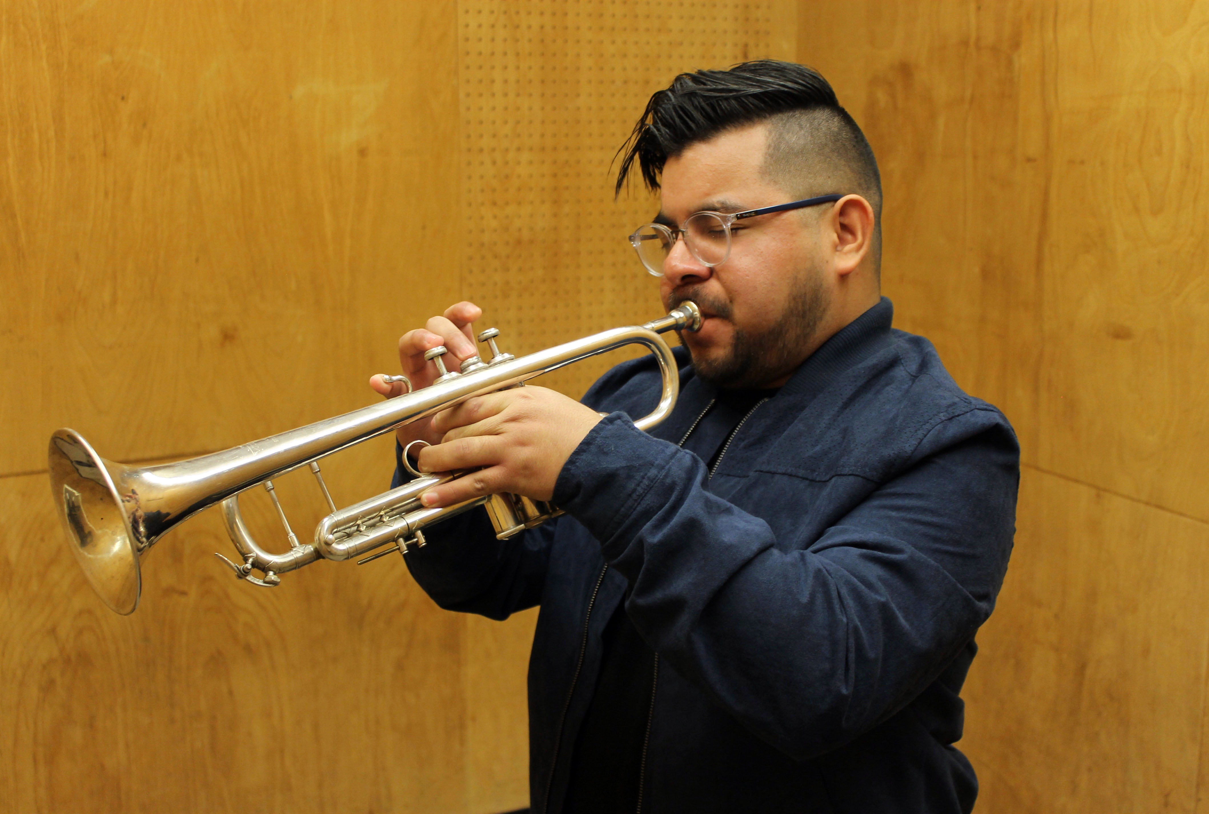 Jonathan De La Cruz practicing with his trumpet