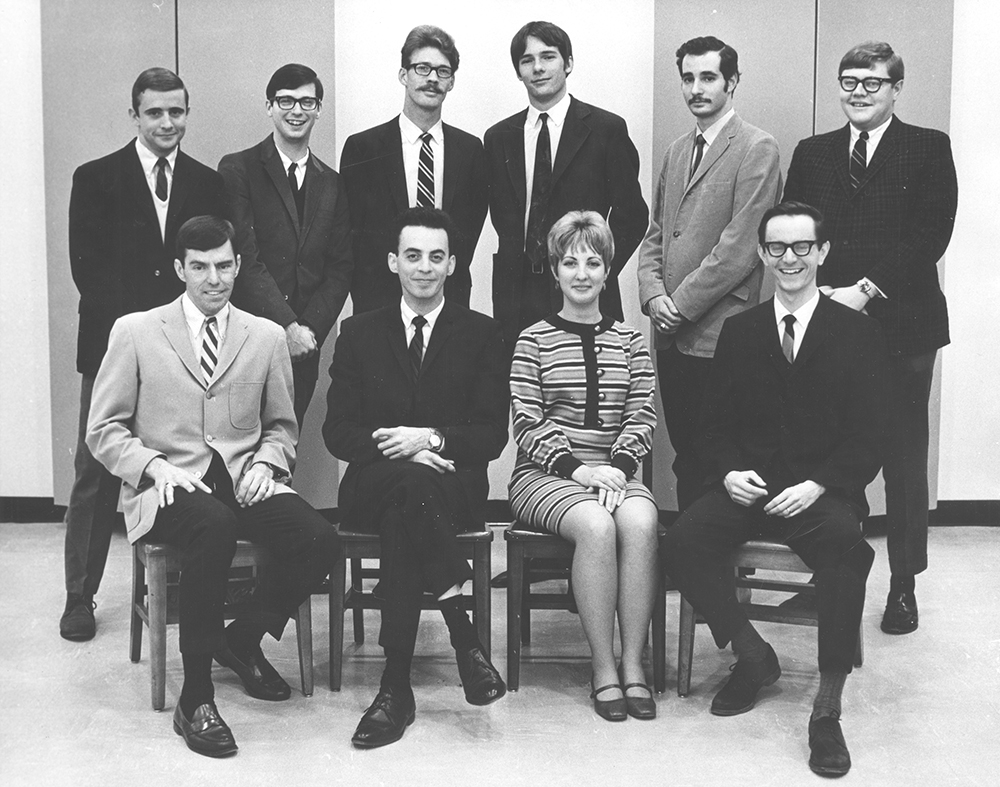 WFIU staff 1967. Front row (left to right): John Harrell, Larry Kroenberger, Debbie Shriner, Don Glass. Back row (left to right): Dave Smith, Tom Gray, George Walker, David Kennard, Elliot Oring, and Dave Champaigne.