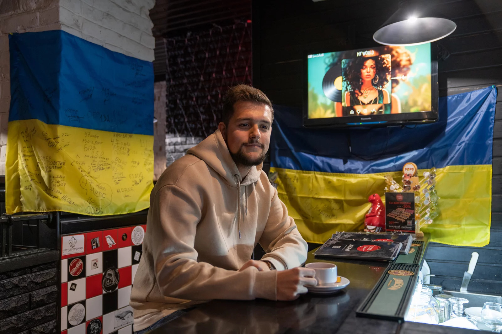 Man sitting at a bar surrounded by Ukrainian flags