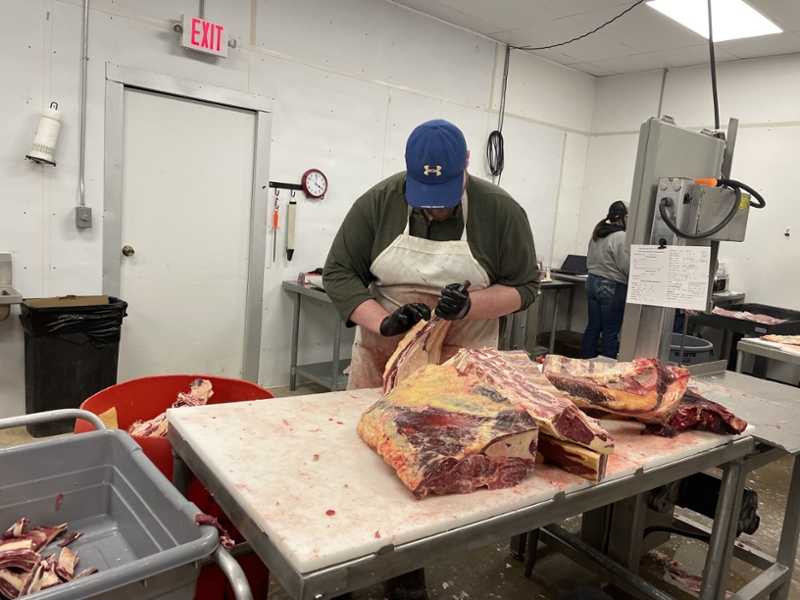 employee carving cow carcass