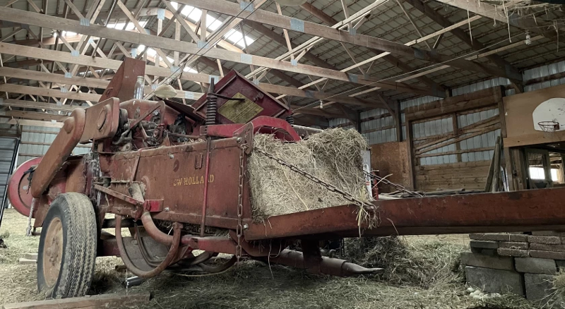 An old baler inside a barn
