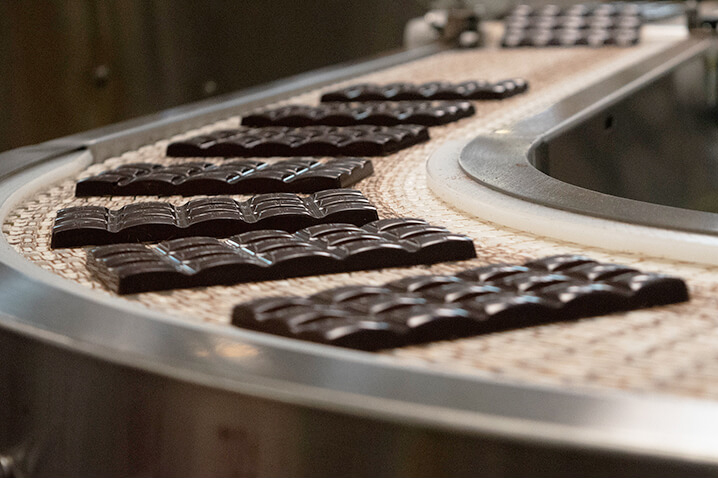 Chocolate bars going around a bend on a factory conveyor belt.