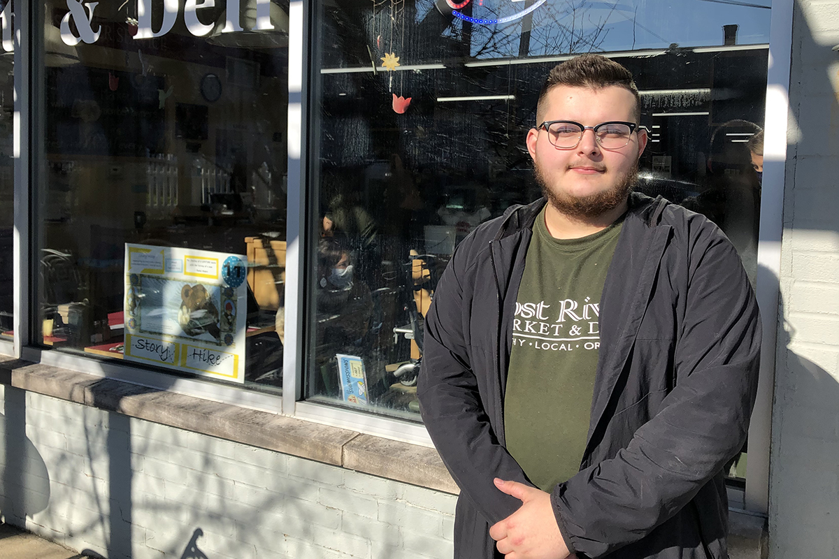 Colin Spear standing by a store front window