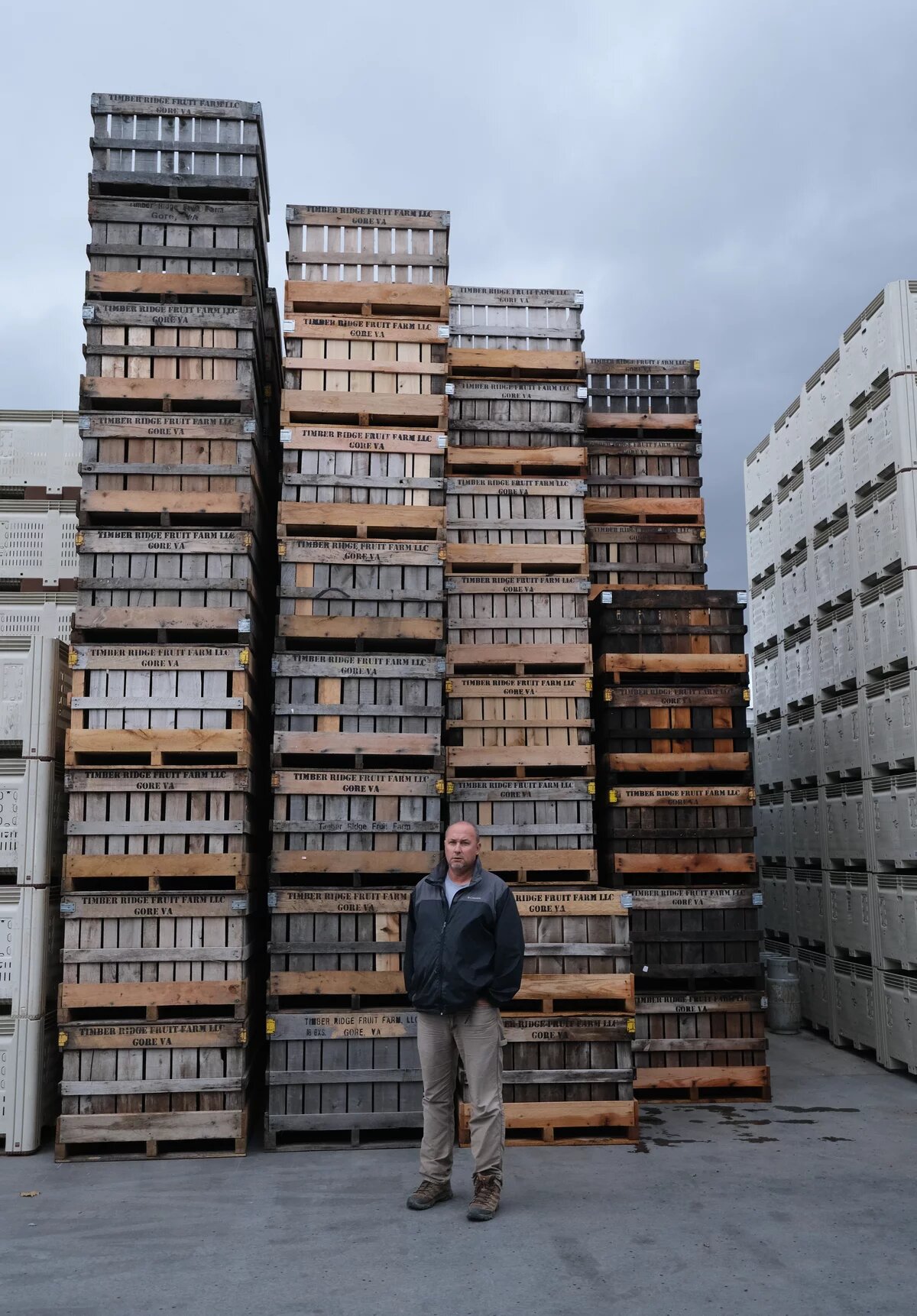 man standing by a stack of crates