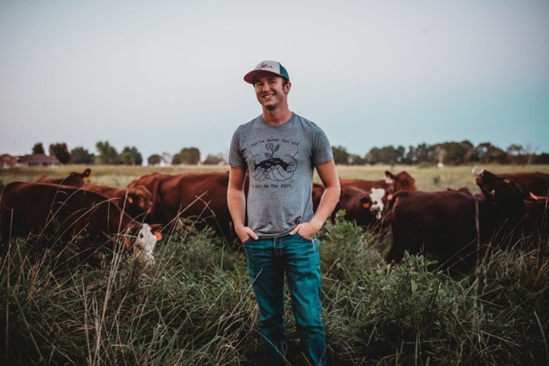 Macauley Kincaid surrounded by cattle at his farm in Jasper, Missouri