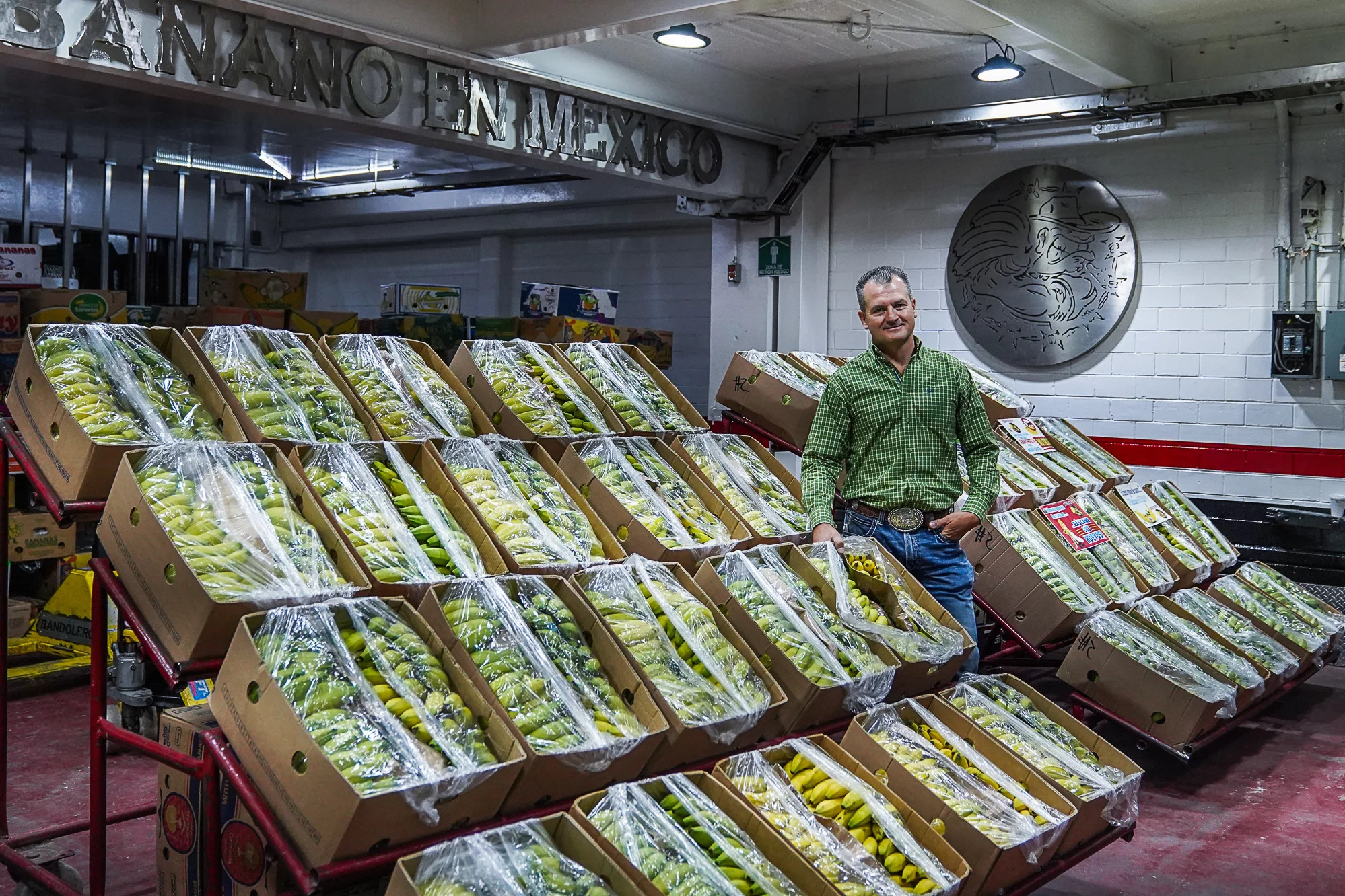 Jorge Gutiérrez poses next to crates of bananas