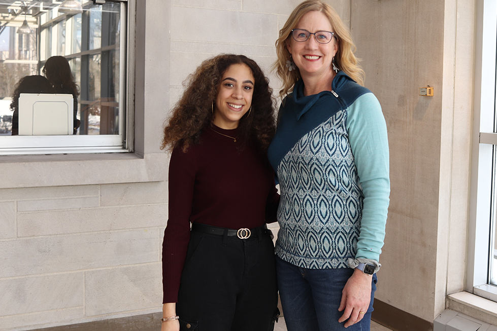 Kayleigh Dance and Laura Scheper standing close together with windows and limestone wall in background