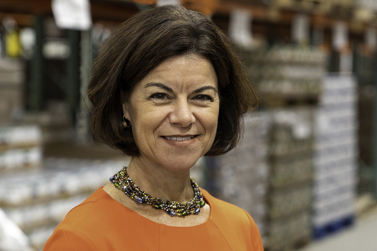 Head shot of Katie S. Martin with blurry pallets of products in a wearhouse in backgroun