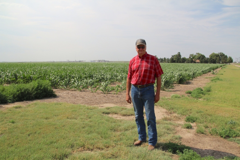 Larry Jones standing in front of farm