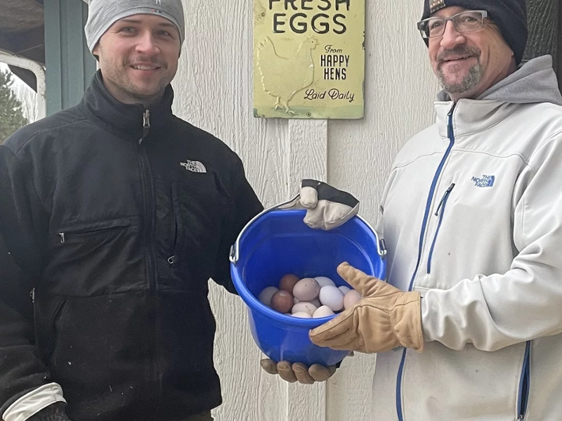 Rom Kern and his son with a bucket of eggs from their farm