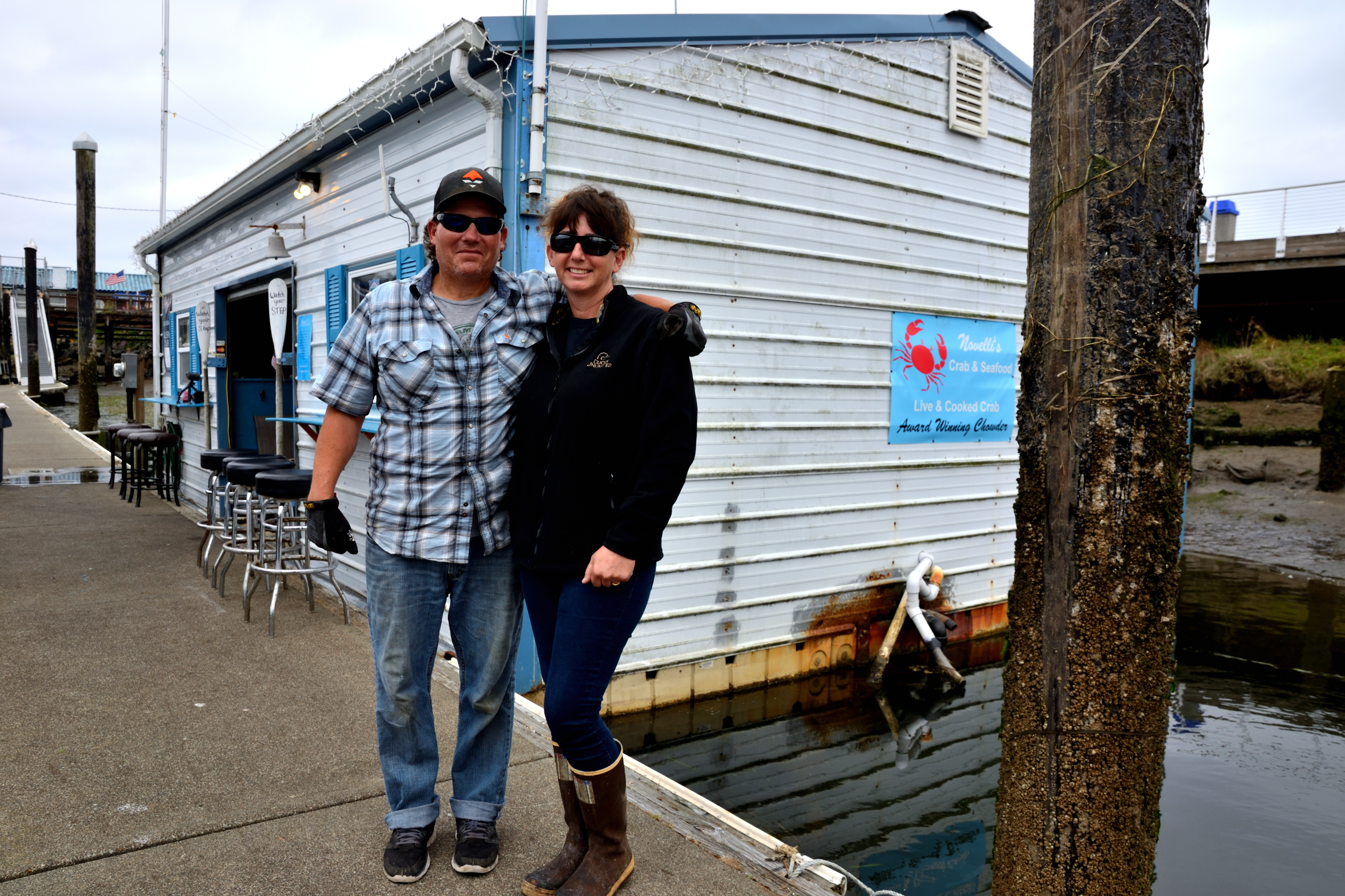 Kyle and Amber Novellie standing on a dock outside of Novellie's Seafood shop. 