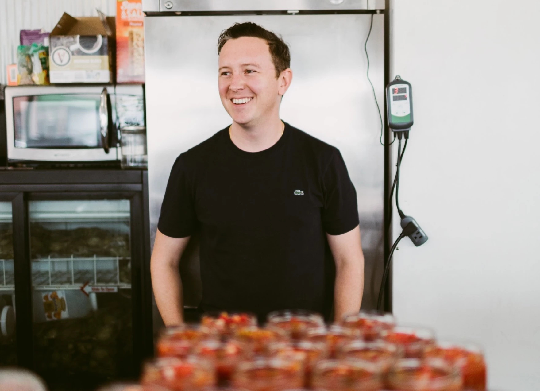 Man smiling in front of jars