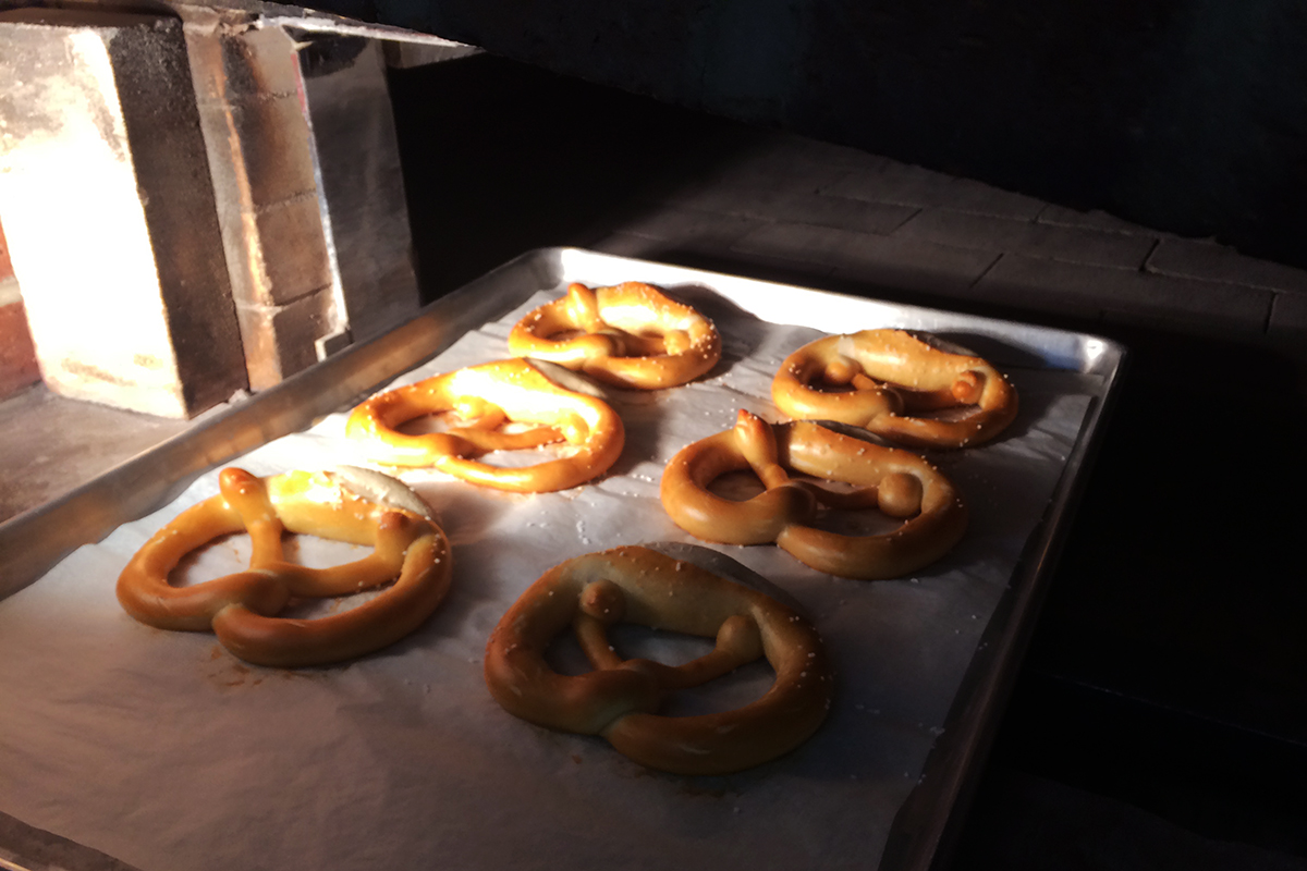 Baked pretzels at the door of a brick oven