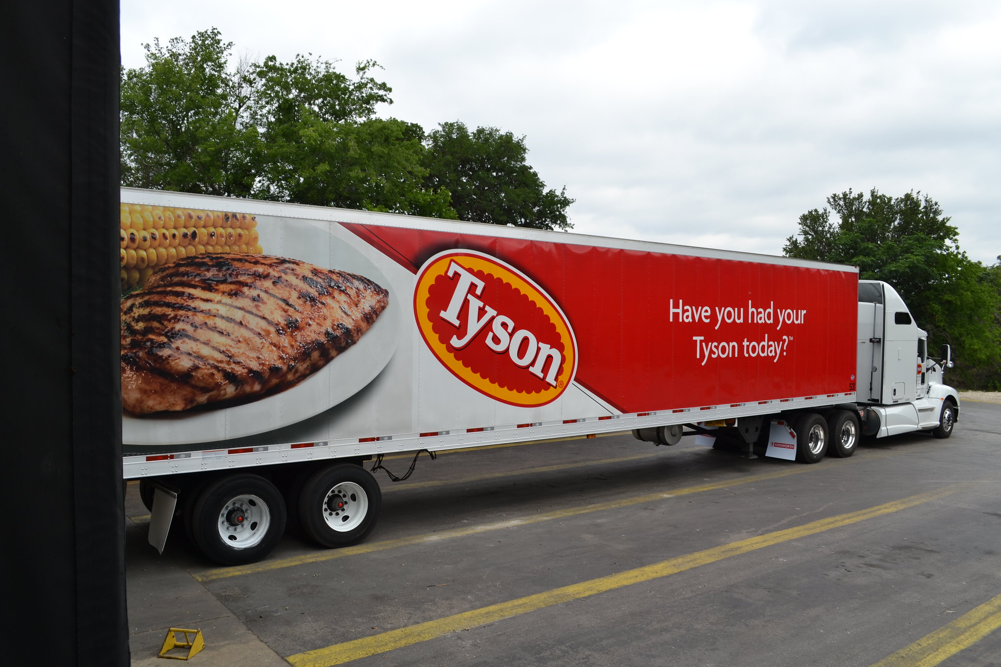 A semi-truck on a road with an image of a plate of food, the Tyson logo and 'Have you had your Tyson today?'