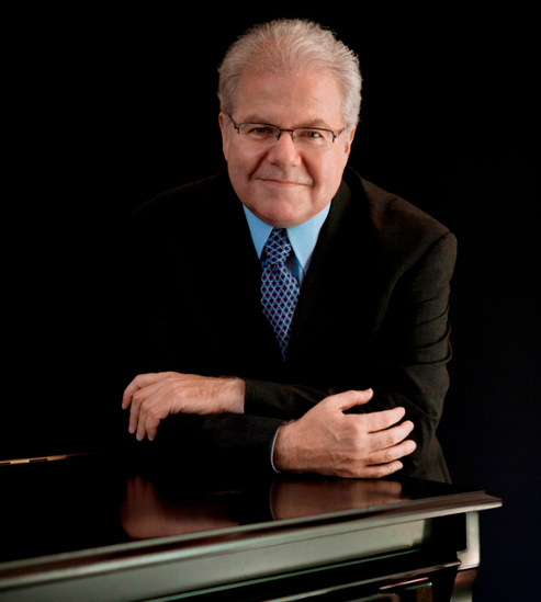 Image of Emanuel Ax leaning on piano