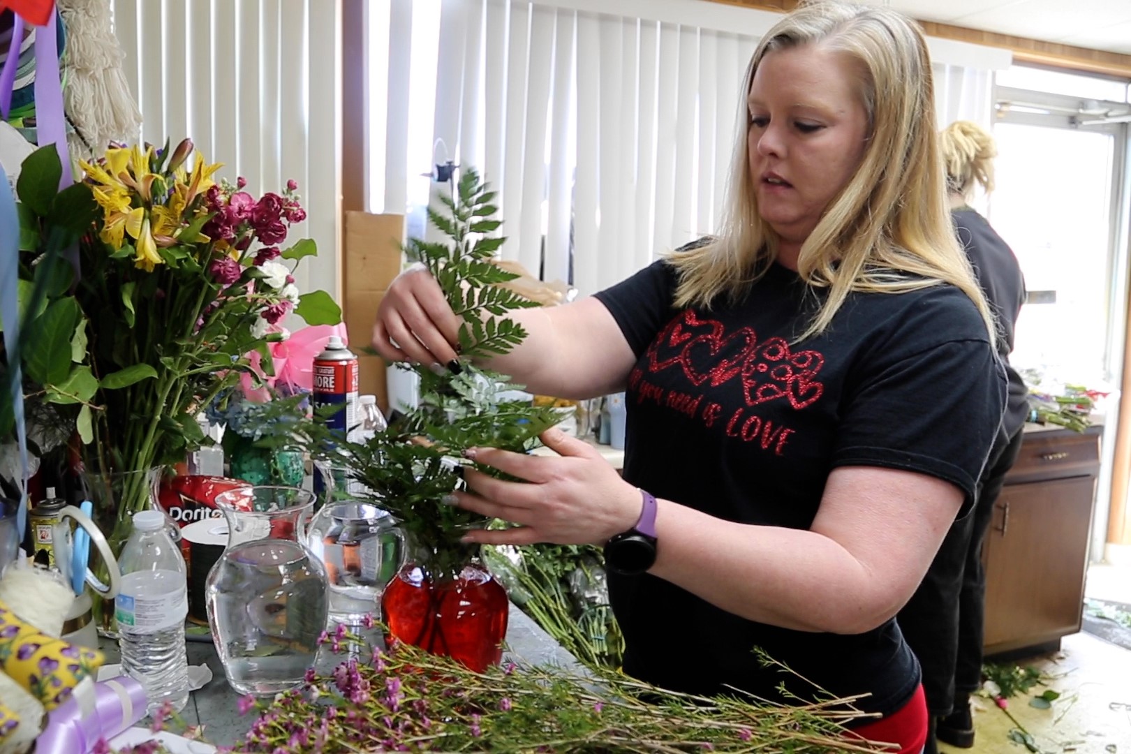 A worker at Mary M's assembles a vase for Valentine's Day