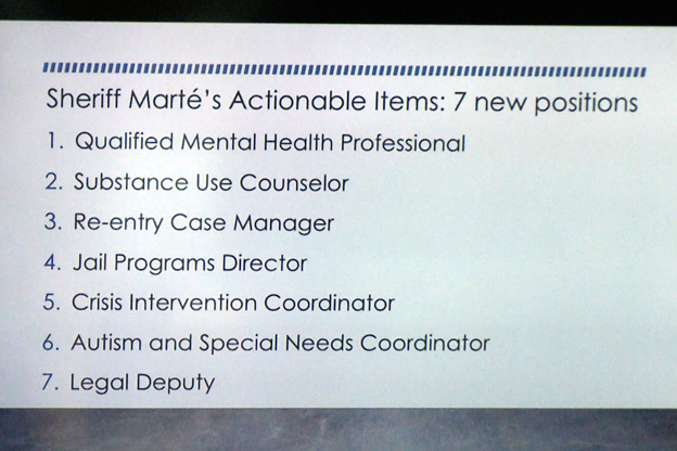 A slide presentation displays the Sheriff's needs for jail staffing.