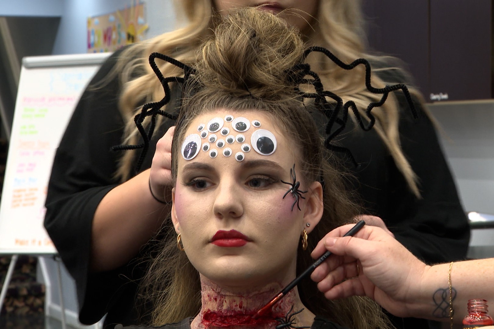 Cosmetologist student Izzie Pruett models a spider makeup design.