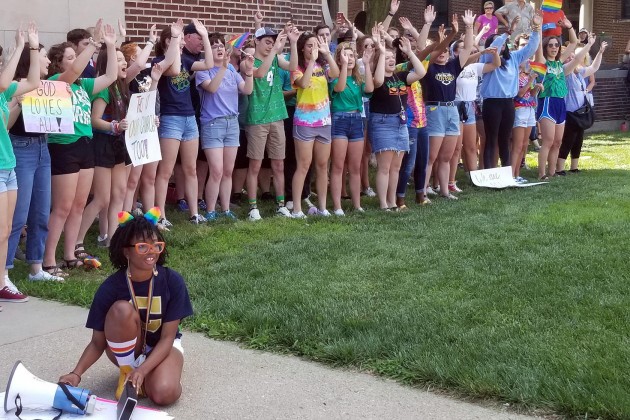 Student organizer Brooklynn Thorpe uses a megaphone to amplify music as fellow students lead school chants and cheers outside of the Archdiocese of Indianapolis during a protest Thursday, June 27, 2019. 