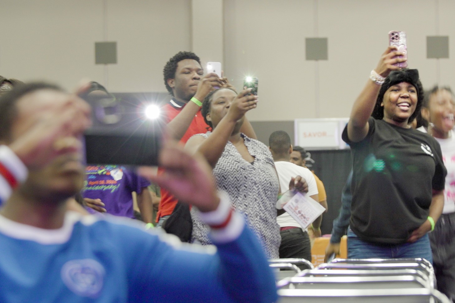 Haitian Anika Johnson, 16 (black t-shirt) cheers for her community members dancing on stage. Haitians are one of the largest group of international students at EVSC.