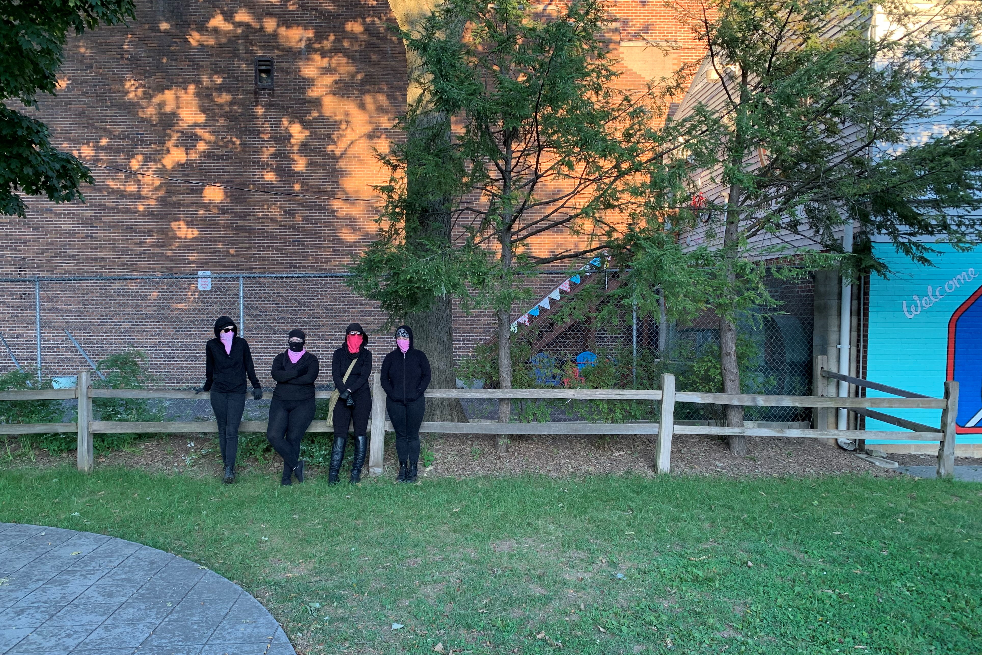 People in all black attend the rally before the march.