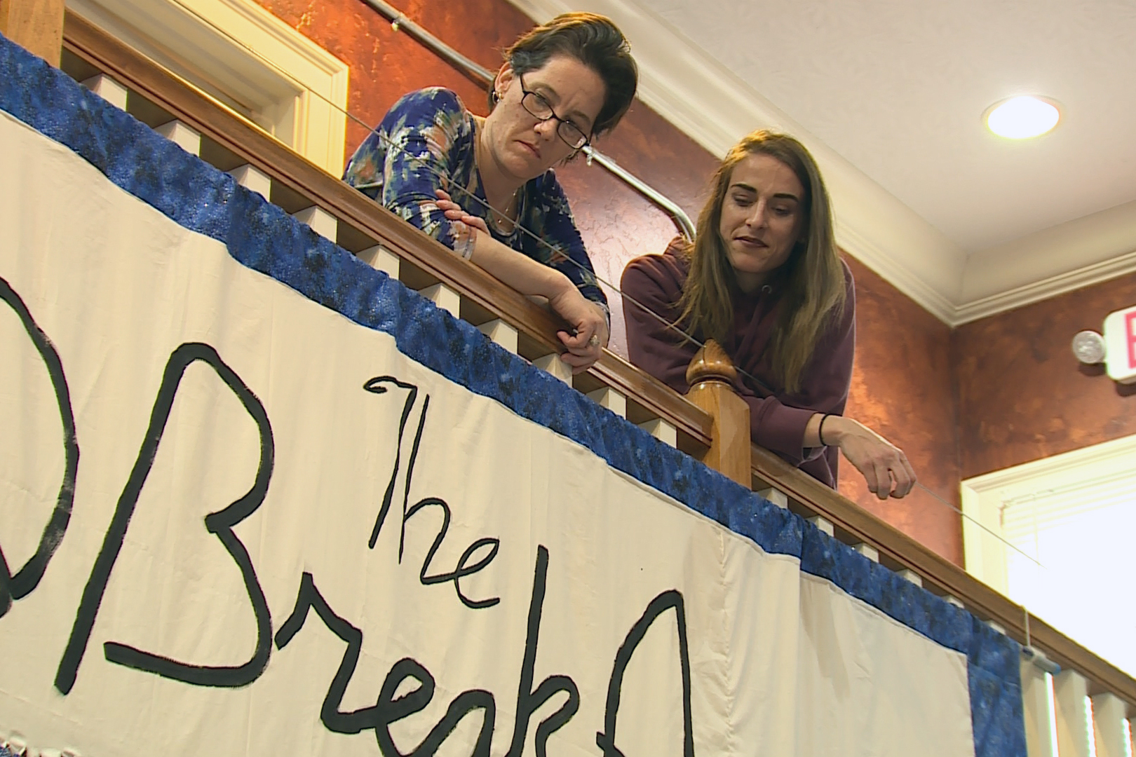 women lean on rail 