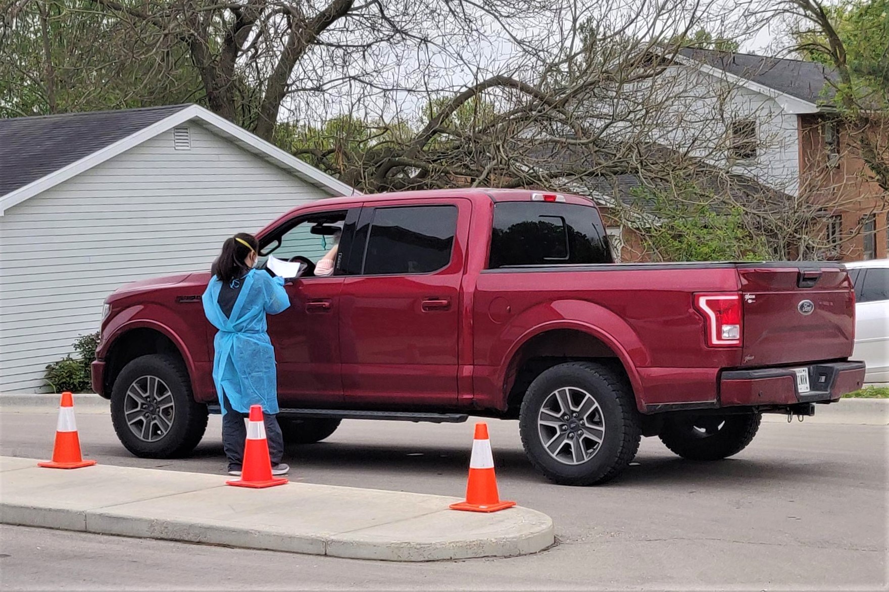 A healthcare worker speaks with someone in a coronavirus drive thru testing facility in Bloomington.