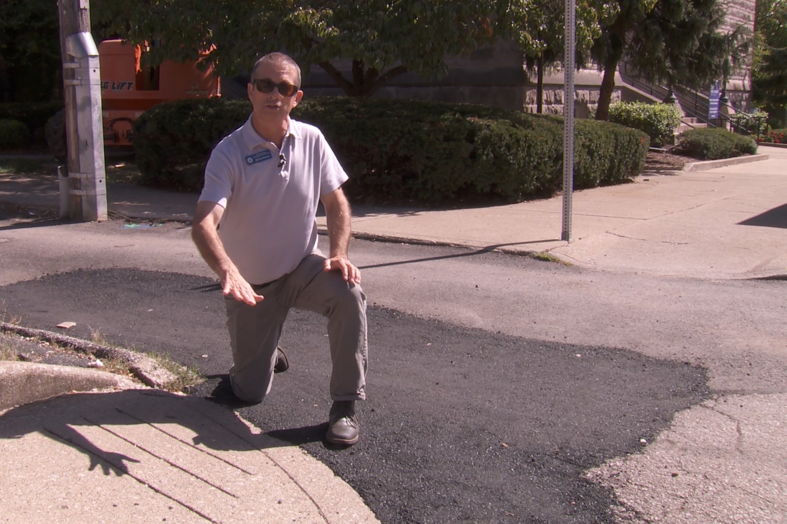 Man showing a recently repaired area of sidewalk