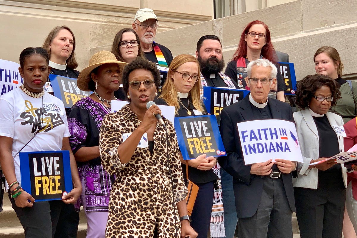 Shonda Nicole Gladden, holding the microphone, speaks on the Indiana Statehouse steps with members of Faith in Indiana, Tuesday, Aug. 13, 2019.