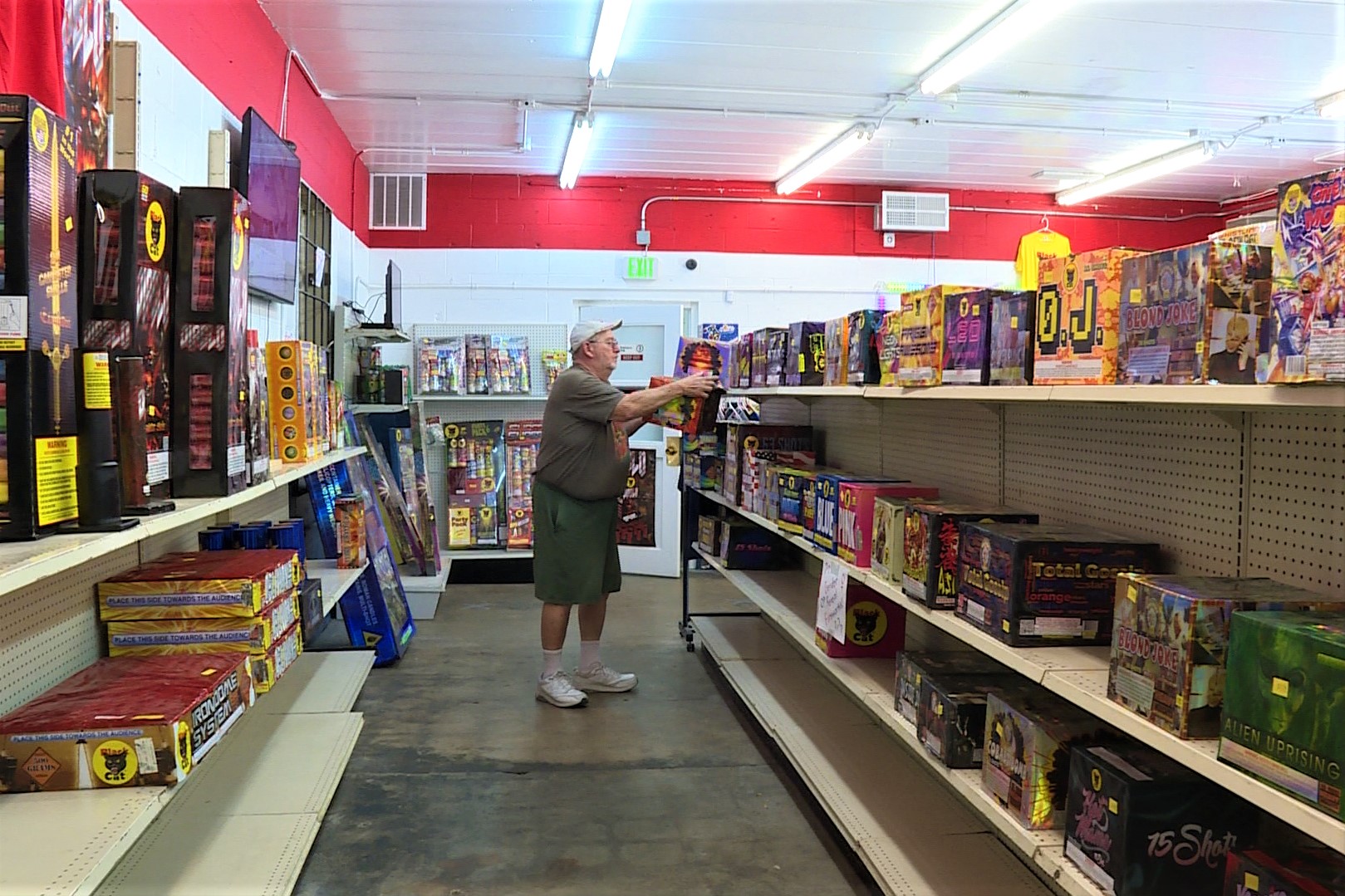 A man browsing the shelves of a fireworks store.