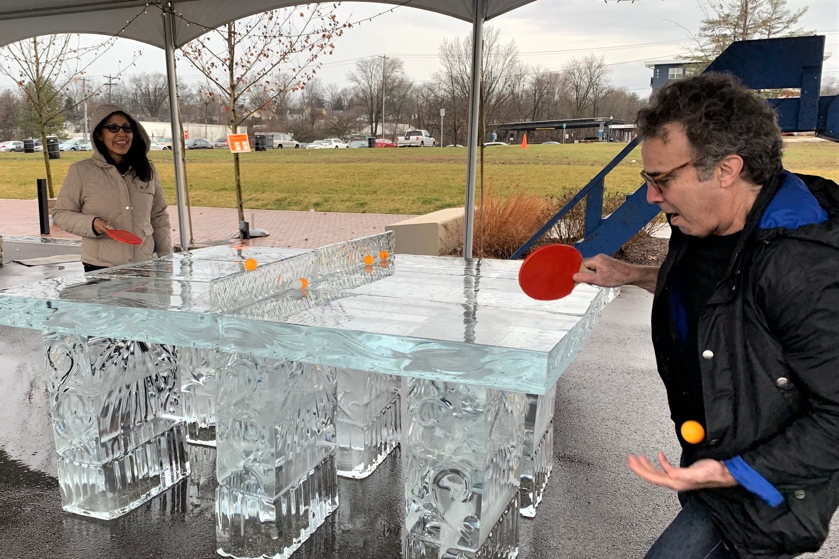 Doris Loayza and Mitch Teplitsky play ping pong at an ice sculpture at Bloomington's Freezefest.