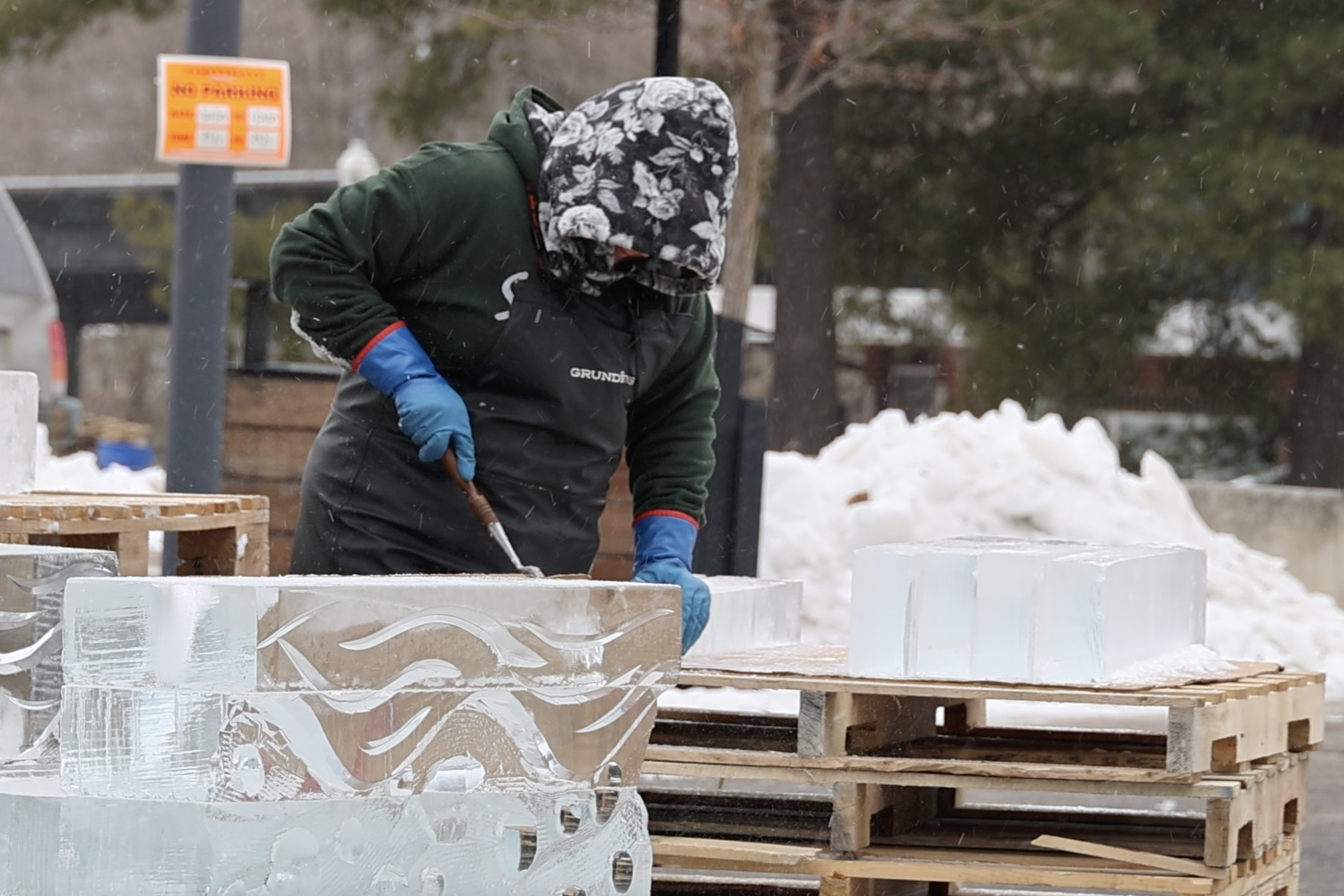 An ice sculptor works on a block of ice at Freezefest 2025 Thursday.