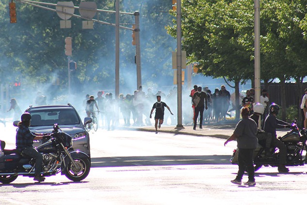 Demonstrators flee tear gas at the corner of New York Street and Capitol Ave.