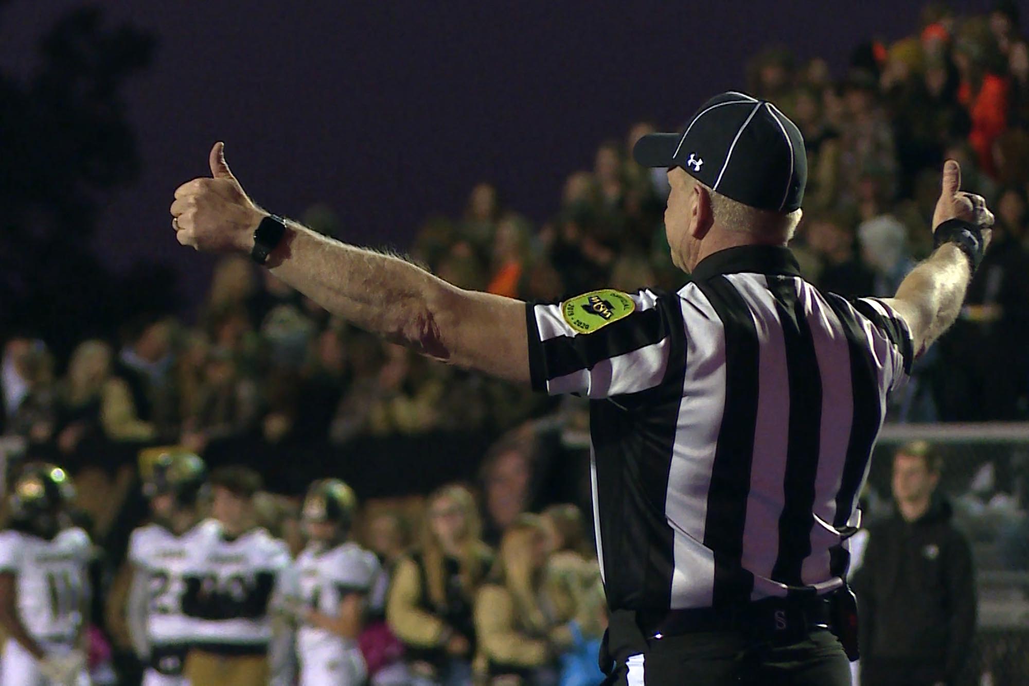 A shot of a high school football referee/official from the back.