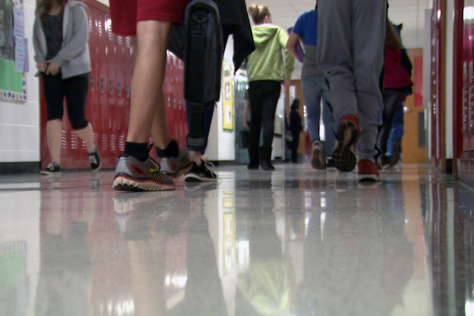 Students walk along a hallway of a high school.